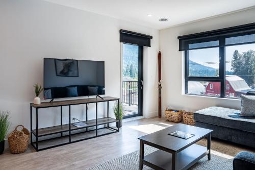 a living room with a couch and a tv at The Grizzly Basin by Revelstoke Vacations in Revelstoke