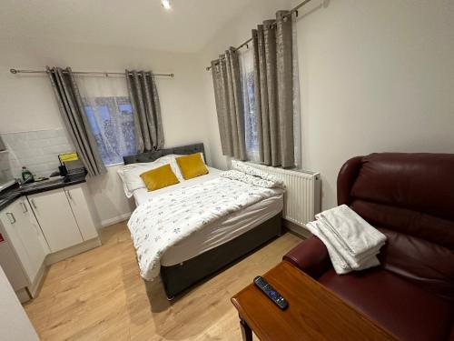 a small bedroom with a bed and a couch at 1st Studio Flat With full Private Toilet And Shower With its Own Kitchenette in Keedonwood Road Bromley A Fully Equipped Independent Studio Flat in Bromley