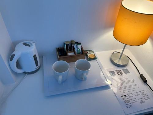 a desk with two mugs on a table with a lamp at Upper Rock Brighton – Guest House in Brighton & Hove