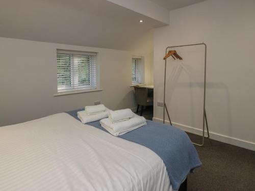 a bedroom with a bed with two towels on it at Edgemere Hideaway in Grange Over Sands
