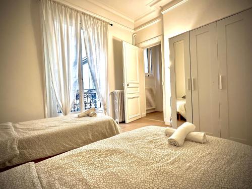 une chambre d'hôtel avec deux lits et une fenêtre dans l'établissement Champs Élysées appartement 5, à Paris