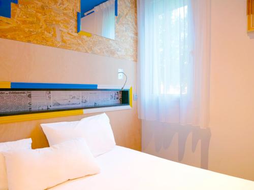 a bedroom with a white bed and a window at greet Hotel Marseille Provence Aéroport in Vitrolles