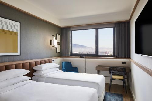 a hotel room with two beds and a television at Four Points by Sheraton Barcelona Airport in Barcelona