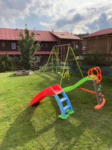 a playground with a swing set in a yard at Apartmán Kocourkov in Jáchymov