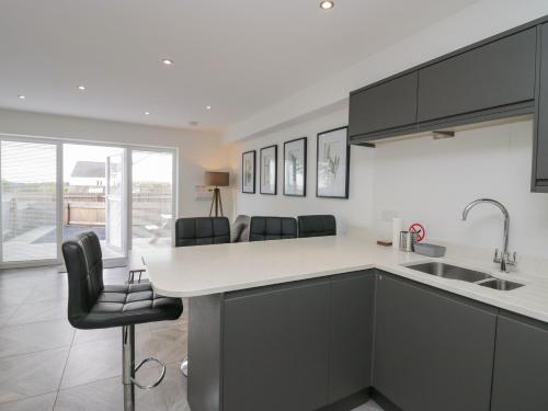 a kitchen with black cabinets and a white counter top at Edgemere Retreat in Grange Over Sands
