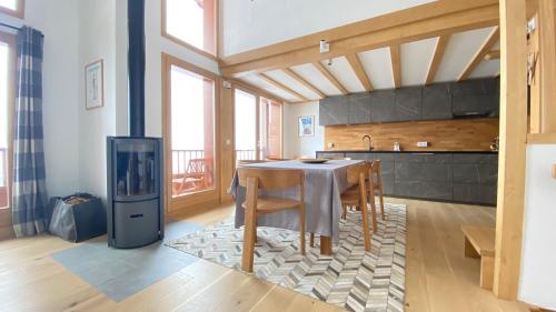 - une cuisine avec une table, des chaises et une cuisinière dans l'établissement La Bergerie 10-12 personnes au pied des pistes à Montalbert, à Montalbert