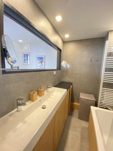 une salle de bain avec un lavabo et une grande fenêtre dans l'établissement La Bergerie 10-12 personnes au pied des pistes à Montalbert, à Montalbert