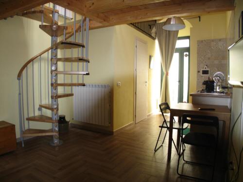 a spiral staircase in a room with a table and chairs at Pozzo Luce in Palazzolo Acreide