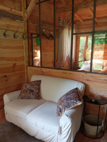 a couch in the living room of a log cabin at La maison du pêcheur in Saint-Justin