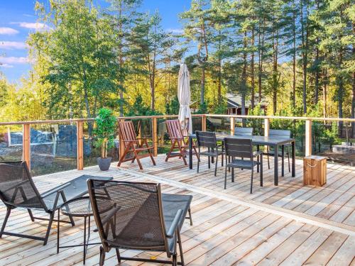 eine Terrasse mit Stühlen, Tischen und einem Sonnenschirm in der Unterkunft Holiday Home Pikku-hovila by Interhome in Tahkovuori