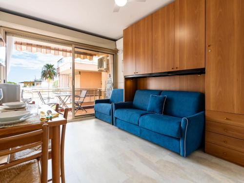 a living room with a blue couch and a table at Apartment AcquadiMare by Interhome in Sanremo