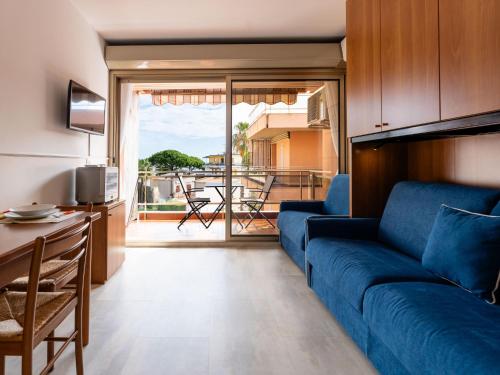 a living room with a blue couch and a balcony at Apartment AcquadiMare by Interhome in Sanremo