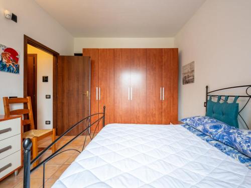a bedroom with a bed and a wooden cabinet at Apartment Nonno by Interhome in Portacomaro