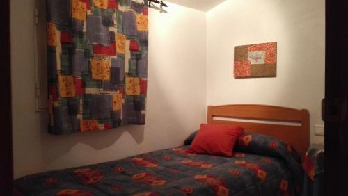 a bedroom with a bed and a quilt on the wall at Casa rural Foreset in Alfara de Carles