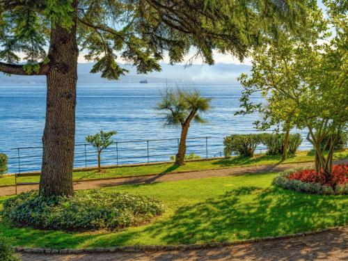a park with trees and the ocean in the background at Holiday Home Villa More by Interhome in Lovran