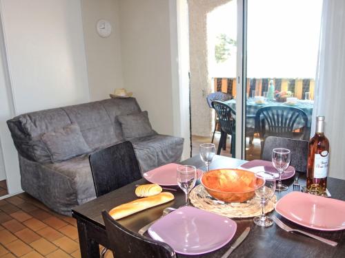 - une table à manger avec des assiettes roses et une bouteille de vin dans l'établissement Apartment Les Aigues Marines-62 by Interhome, à Saint-Cyr-sur-Mer
