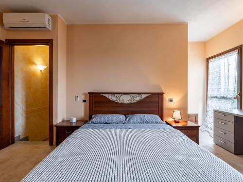 a bedroom with a large bed with a wooden headboard at Holiday Home Zio-Nonno by Interhome in Portacomaro