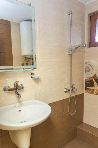 a bathroom with a sink and a shower at Къща за гости КАТИ in Kiten