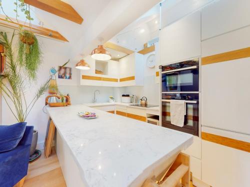 a kitchen with a large white counter top in a room at Pass the Keys Elegant flat in trendy Hampstead in London