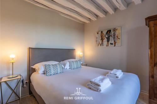 une chambre avec un grand lit blanc avec des serviettes dessus dans l'établissement The Lighthouse Charming Apartment Beach & City Center 2-4 pers, à Honfleur