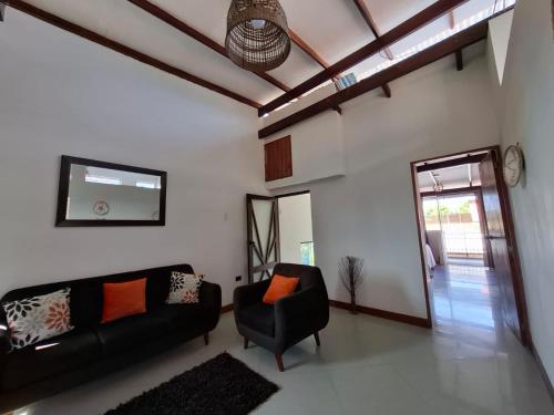 a living room with a black couch and a mirror at Acogedor Apartamento en Tarapoto in Tarapoto