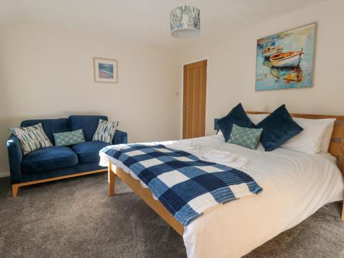 a bedroom with a bed and a blue couch at Victoria House in Weymouth