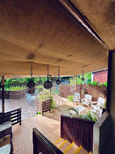 a patio with chairs and a table and swings at Pousada do Golfinho Fernando de Noronha in Fernando de Noronha