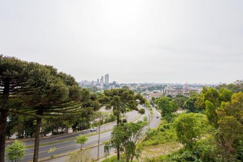 a view of a city with a road and trees at Studio com 1 Cama de Casal e 1 Solteiro - ECO0509 in Curitiba