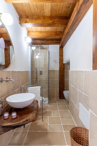 a bathroom with a sink and a toilet and a mirror at Talassa - Dimora di Charme Suite con vasca idromassaggio in Taranto