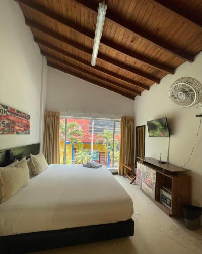 a bedroom with a large bed and a large window at Hostal Lleras Calle 8 in Medellín