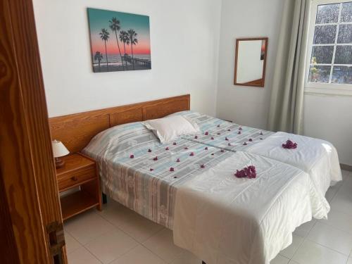 Un dormitorio con una cama con rosas. en Apartamento Luz y Mar, en Tazacorte