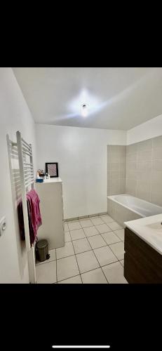 une salle de bain blanche avec une baignoire et un lavabo dans l'établissement Chambre confortable à 25min de Paris, à Villemomble