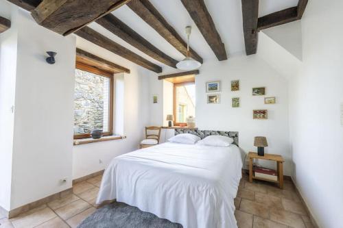 une chambre avec un lit blanc et une fenêtre dans l'établissement Maison de campagne au Domaine, à La Souris