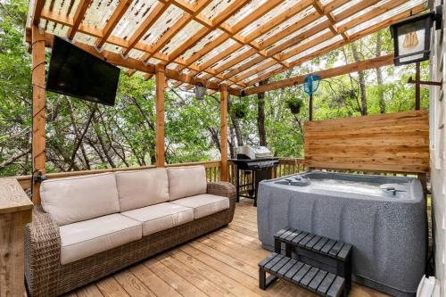 a patio with a couch and a hot tub on a deck at Cozy Coop Casita - Lake Travis-Hot Tub-Tiny House in Austin