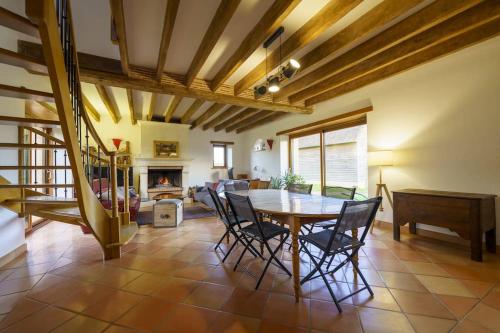 une salle à manger avec une table et des chaises et une cheminée dans l'établissement Maison de campagne au Domaine, à La Souris