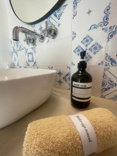 a bathroom with a bottle of soap and a rug at B&B Quinta a Fonte Tavira - Adults Only in Tavira