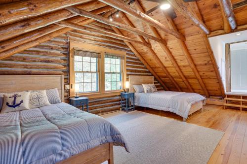 Un dormitorio con dos camas en una cabaña de madera. en Virginia Retreat on Wicomico River with Dock!, en Reedville