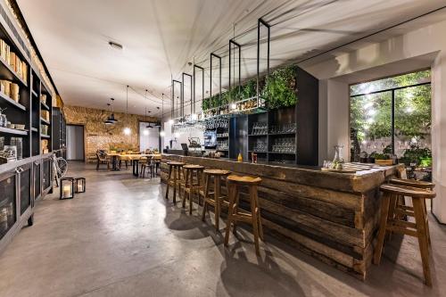 a restaurant with a wooden bar with wooden stools at Sapientia Boutique Hotel in Coimbra