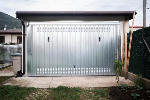 a metal garage door with aphaltphaltphaltphalt at Giardino Privè - Casa Aldo in Arcisate