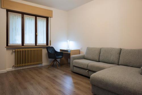 a living room with a couch and a desk at Giardino Privè - Casa Aldo in Arcisate