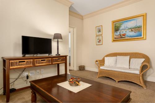 a living room with a television and a couch at Gable Manor by Neighbourgood in Franschhoek