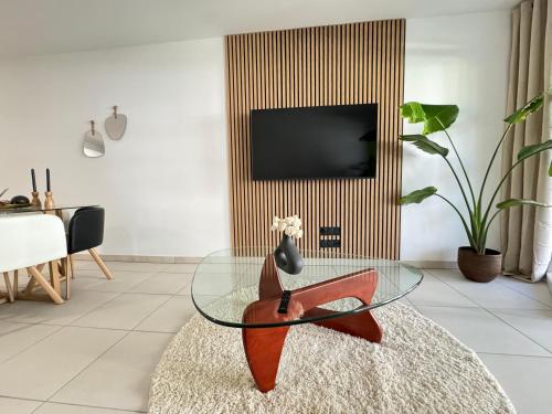 un salon avec une table en verre et une télévision dans l'établissement Appartement T3 moderne et cosy, à Hopitaux-Facultés, à Montpellier