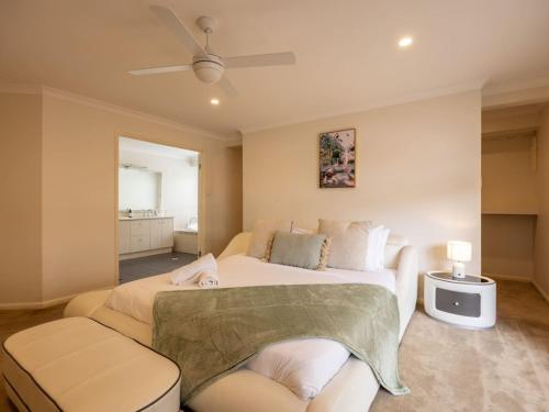 a bedroom with a large bed and a couch at Mins to Shop n Lake 4 beds family retreat with pool in Doolandella