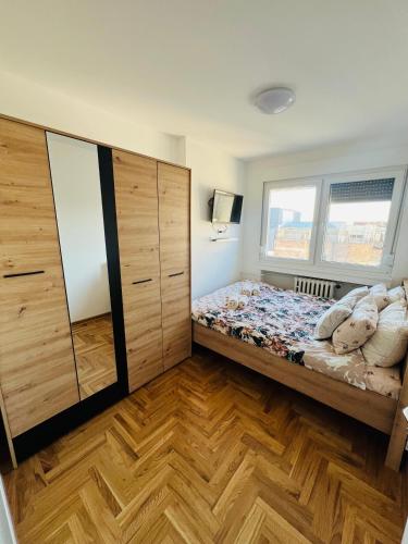 a bedroom with a bed and a large wooden cabinet at Apartment Ninana in Belgrade