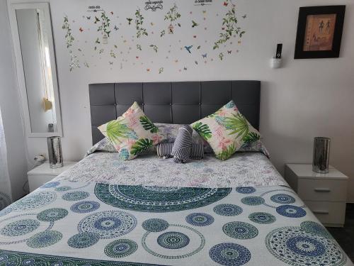 a bedroom with a bed with colorful pillows at Casa Oasis Puertollano, una casa rural en Puertollano, agradable, con Piscina en zona tranquila in Puertollano