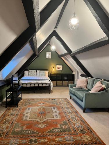 a attic room with a couch and a bed at Heathcote House in Milborne Saint Andrew