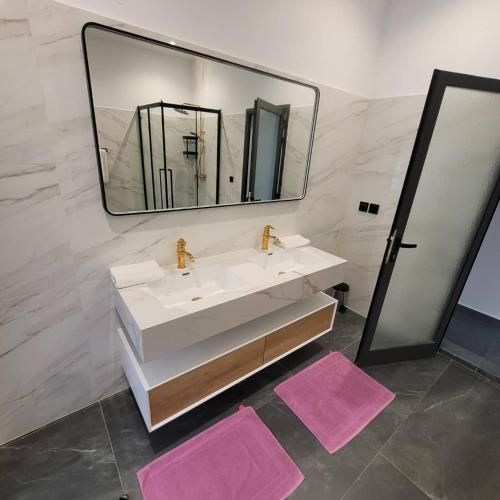 Sali TapéにあるHotel matyのバスルーム(シンク、鏡、ピンクのマット2枚付)