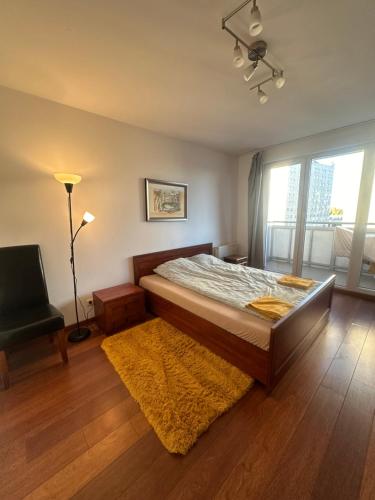 a bedroom with a bed and a chair and a window at Private Apartment Poznań - Free Parking - Netflix in Poznań