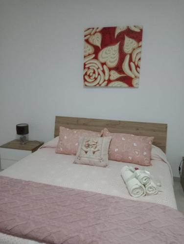 a bed with pink and white blankets and pillows at Casa Vacanza Luna in Palagiano