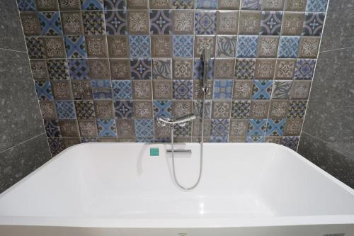 a bath tub with a faucet in a bathroom at HOTEL YUNA Business in Busan